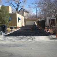 Person using a hand tool to install Ecoraster permeable paving on a residential driveway