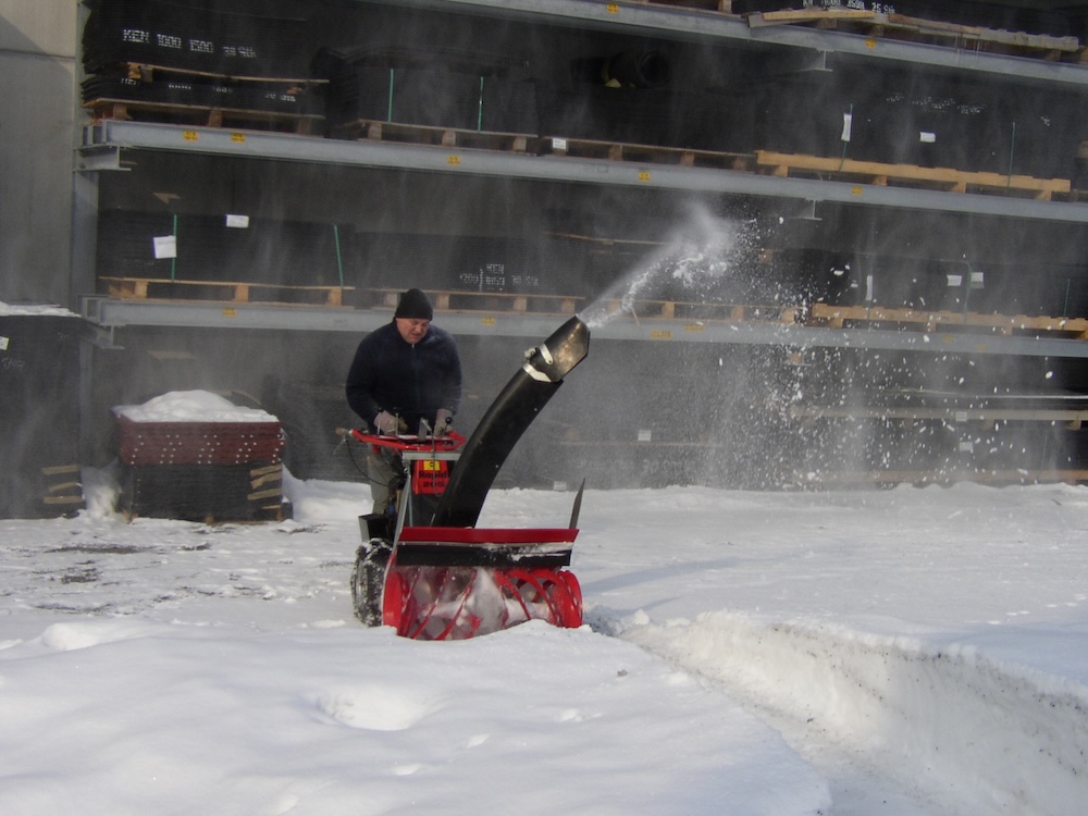 person easily using a snowblower on permeable paving