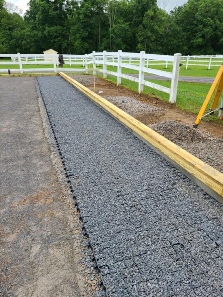 Gravel-filled Ecoraster grid laneway along a paddock fence to control mud and drainage problems