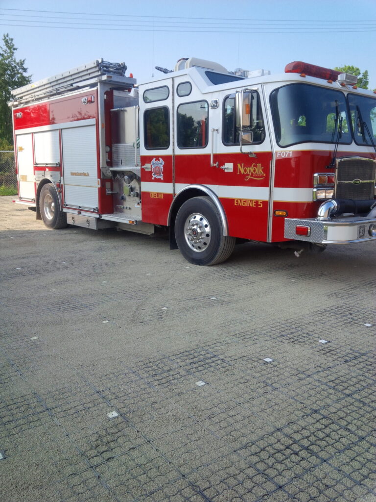 Fire truck parked on a gravel-filled ECORASTER permeable surface used for emergency access.